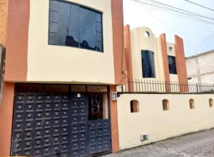 un edificio con una puerta de garaje y una valla en CASA VACACIONAL NACHO, en Baños