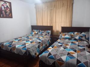 dos camas sentadas una al lado de la otra en un dormitorio en CASA VACACIONAL NACHO, en Baños
