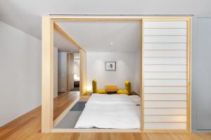 1 dormitorio con 1 cama a través de una puerta corredera en YAMAKEI Residences en Niseko