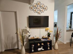 a living room with a television and a table with vases at Kona Mansions in Kailua-Kona