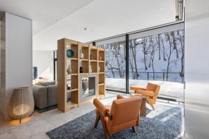 a living room with a couch and a table and chairs at YAMAKEI Residences in Niseko