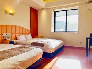 a hotel room with two beds and a window at Hotel Square FujiGotemba in Gotemba