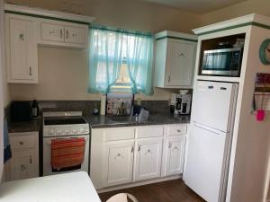 a kitchen with white cabinets and a white refrigerator at Rio grand country getaway in Harlingen