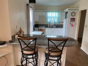 a kitchen with a counter and two bar stools at Rio grand country getaway in Harlingen