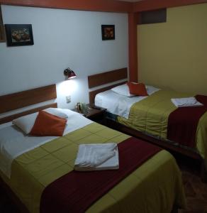 Habitación de hotel con 2 camas y toallas. en Hospedaje Del Carmen, en Machu Picchu