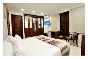 een slaapkamer met een groot wit bed in een kamer bij Phoenix Luxe Roooms in New Delhi