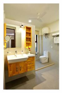 uma casa de banho com um lavatório e um WC em Phoenix Luxe Roooms em Nova Deli
