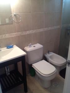 y baño con aseo blanco y lavamanos. en Apartamento En Las Delicias, en Punta del Este