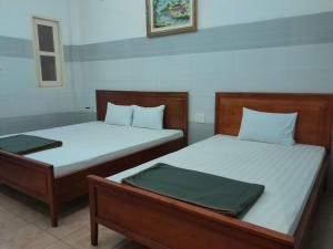 twee bedden naast elkaar in een kamer bij An An Hotel in Ho Chi Minh-stad