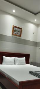 een bed in een slaapkamer met een foto aan de muur bij An An Hotel in Ho Chi Minh-stad