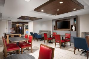 a restaurant with tables and chairs and a flat screen tv at Holiday Inn Express & Suites Chattanooga-Hixson by IHG in Hixson