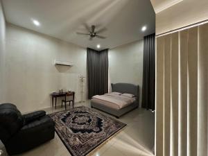 a bedroom with a bed and a couch and a table at Balqish House in Seremban