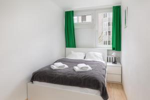 a white bedroom with green curtains and a bed at Ecru Apartment near Norblin Factory WWA76 in Warsaw
