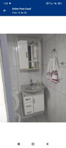 uma casa de banho com um lavatório e um WC em Suítes Para Casal em Bertioga