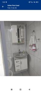 a bathroom with a sink and a toilet at Suítes Para Casal in Bertioga