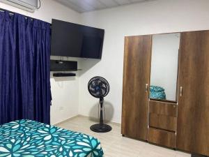 a bedroom with a fan next to a wooden cabinet at Cómoda casa cerca al centro in San José del Guaviare