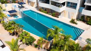 - une vue sur la piscine dans un bâtiment avec des palmiers dans l'établissement Azure Sea Whitsunday Resort, à Airlie Beach