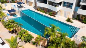 an overhead view of a swimming pool in a building with palm trees at Azure Sea Whitsunday Resort in Airlie Beach