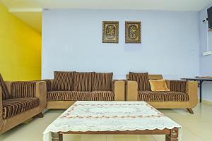 a living room with two couches and a coffee table at OYO 275 Senyum Inn in Pantai Cenang