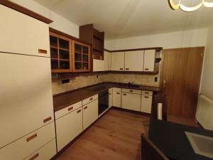 an empty kitchen with white cabinets and wooden floors at Wirtin z Atzersdorf 