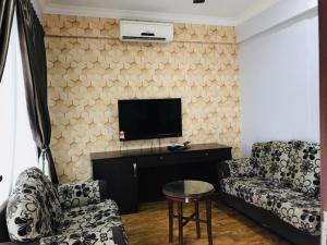 a living room with a couch and a flat screen tv at Zaque's Hotel in Sungai Petani