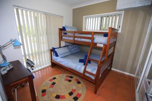 una habitación con dos literas y una mesa en BankSea Holiday Home, en Agnes Water