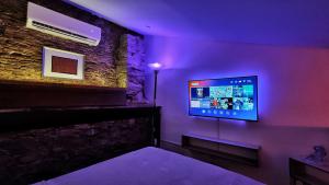 Zimmer mit einem TV in einem lila Zimmer in der Unterkunft Loft Studio By Paradox in Panama-Stadt