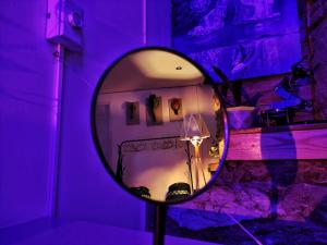 einen Spiegel in einem Zimmer mit lila Licht in der Unterkunft Loft Studio By Paradox in Panama-Stadt