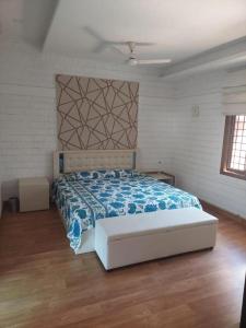 a bedroom with a large bed with a blue blanket at Terrace abode in Mangalore