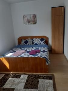 a bed with a wooden frame in a bedroom at Casa Beatrice in Ocna-Mureşului