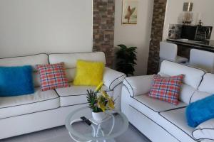 a living room with two white couches and a table at tropicana sur apt221 in Sosúa