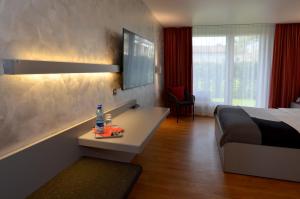 Schlafzimmer mit einem Bett und einem Schreibtisch mit einer Flasche Wasser in der Unterkunft Hotel Egerkingen, idealer Zwischenstopp in Egerkingen