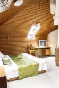 a bedroom with a bed and a desk with a television at Hotel Molnár in Budapest