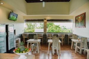 a restaurant with tables and chairs and a large window at Taman Asih Bingin Homestay in Uluwatu