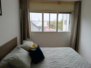een slaapkamer met een bed en een raam bij Apartamento para cuatro personas totalmente equipado in Montevideo