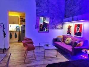 uma sala de estar roxa com um sofá e cadeiras roxos em Space Oddity By Paradox na Cidade do Panamá
