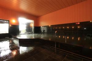 御宿 白金の森 في Kikuchi: غرفة رطبة مع حوض استحمام مع أضواء على الحائط