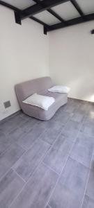 uma cama num quarto com piso em azulejo em La maisonnette cherbourgeoise em Cherbourg en Cotentin