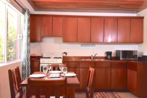 Palmetto Garden Cottage في كاي كولكر: مطبخ مع طاولة وغرفة طعام