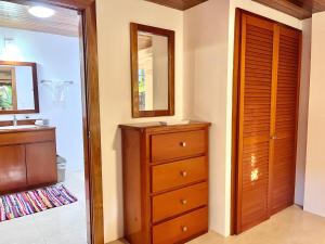 Palmetto Garden Cottage في كاي كولكر: حمام مع حوض وخزانة ومرآة