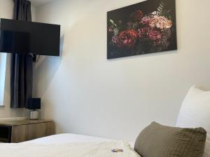 1 dormitorio con 1 cama y una foto de flores en la pared en Apartments im Chateau d'Esprit, en Höhr-Grenzhausen