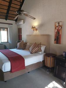 哈玆維尤的住宿－Dreamy 3 bedroom villa on the edge of the Sabie River in Kruger Park Lodge，一间卧室配有一张大床和枕头