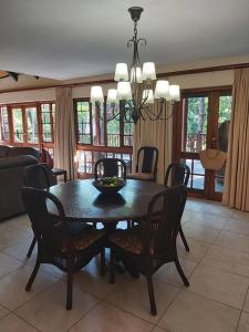 a dining table and chairs in a living room at Dreamy 3 bedroom villa on the edge of the Sabie River in Kruger Park Lodge in Hazyview