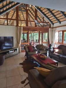 a living room with couches and a flat screen tv at Dreamy 3 bedroom villa on the edge of the Sabie River in Kruger Park Lodge in Hazyview