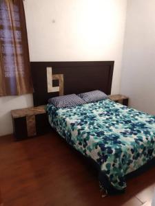 a bedroom with a bed with a flowered comforter at casa de 2 pisos amplia y bonita in Oaxaca City