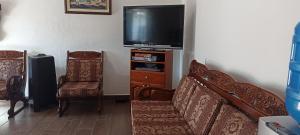 a living room with a couch and a television at La Candelaria, Casa de huéspedes. in Puerto Baquerizo Moreno