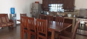 a kitchen with a wooden table and wooden chairs at La Candelaria, Casa de huéspedes. in Puerto Baquerizo Moreno
