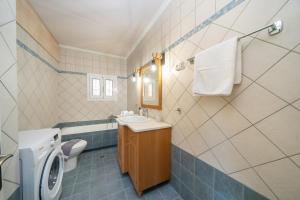 a bathroom with a sink and a toilet and a washing machine at La Casa De Agathi in Argostoli +43 photos