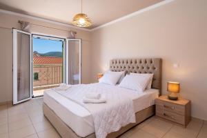 a bedroom with a large bed and a large window at La Casa De Agathi in Argostoli