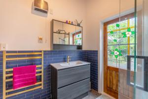 a bathroom with a sink and a mirror at Beautiful villa in Napier with spa in Napier +15 photos